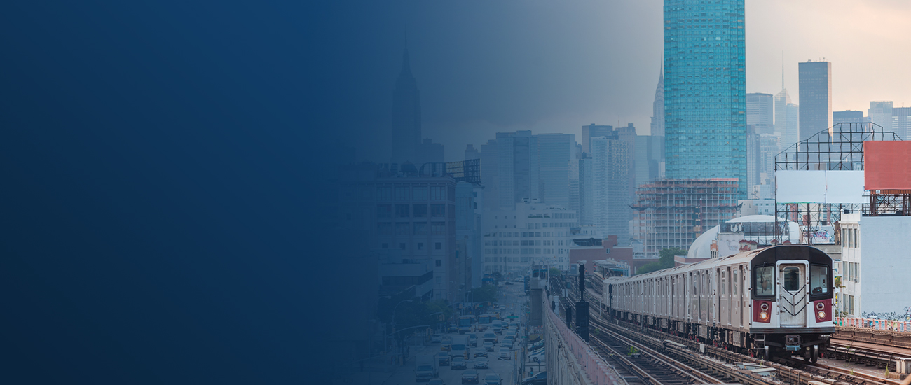 Train approaching in city with skyscrapers in background